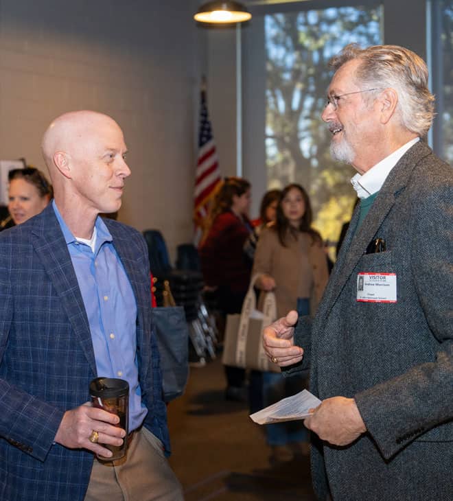 Two men wearing name tags having a conversation